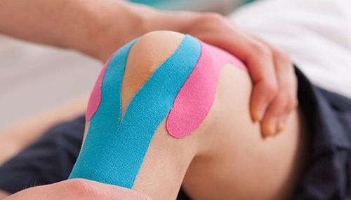 蓝色和粉色的绷带在膝盖上垂直伸展